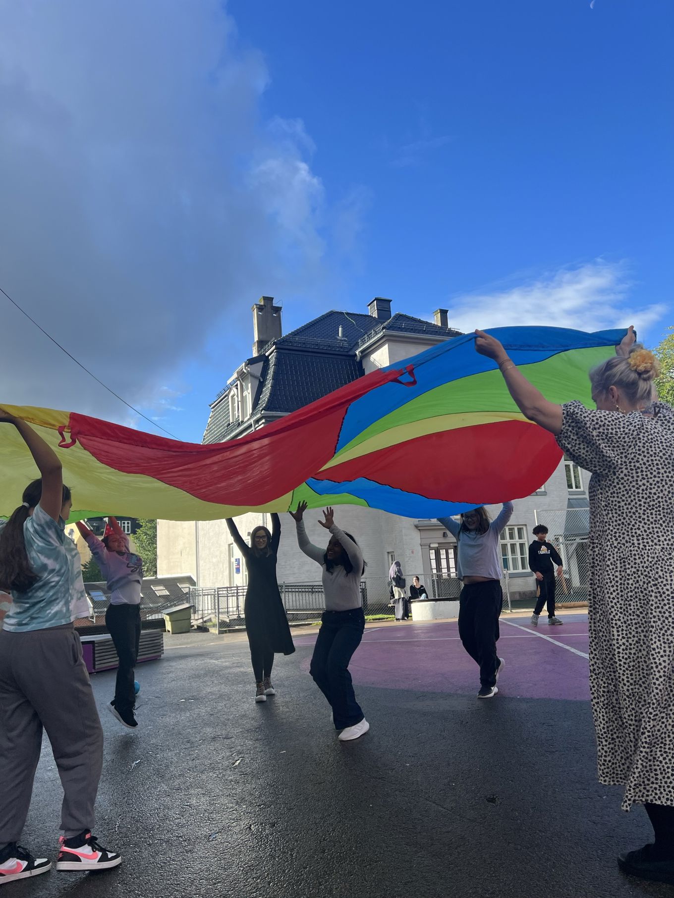 en gruppe mennesker som holder en fargerik drage